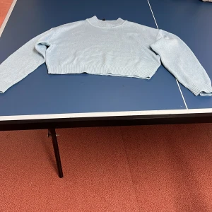 Ljusblå stickad tröja från H&M - Säljer en ljusblå stickad tröja från H&M Divided. Tröjan är croppad med långa ärmar och har en ribbad struktur. 