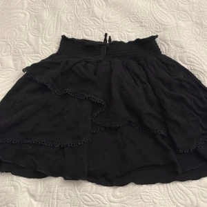 Svart kjol från Lindex - Jätte fin svart kjol i storlek 170 från Lindex kids men passar upp till storlek M. Enda defekten är att en del av rosetten på framsida midjebandet har lossnat upp, men inget större problem! 😊