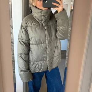 Grön/grå beige pufferjacka - Skitsnygg vinterjacka ifrån hm. Använd men i bra skick. Storlek xs men oversized. 