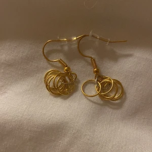 Guldörhängen med cirkeldetaljer - Snygga guldörhängen med flera sammanlänkade cirklar som ger en modern och stilren look. Perfekta för att lyfta vilken outfit som helst med en touch av elegans.