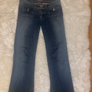 Blå bootcut jeans - Säljer ett par lågmidjade bootcutjeans. Innerbensläng 78 midja 37. De är lite slitna längst ner men annars hela❤️