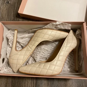 Beige quiltade pumps från Desa - Säljer dessa oanvända klackskor som var lite för stora på mig! Dom är nya, strlk 38 men jag skulle säga att dom passar även om man har 39💕jag säljer dom för halva priset