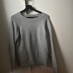 Grå tröja från Vero Moda - Säljer en grå tröja från Vero Moda. Tröjan har en rund halsringning och långa ärmar med ribbade muddar vid ärmslut och nederkant. Rätt så stretchig