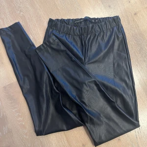 Svarta skinn-leggings  - Snygga svarta leggings i skinn imitation från The Black Label Collection- lager 157.  Strl. M Släppt lite i sömmarna, se bilder. I övrigt jättefint skick. 