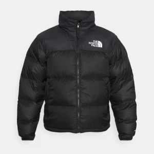 Svart dunjacka från The North Face - Säljer en svart pufferjacka från The North Face med dragkedja och hög krage. Jackan har en broderad logga på bröstet och är perfekt för kalla dagar. Den är väl använd med fortfarande i mycket bra skick! Storleken är XS herr men passar även för S dam. Nypris 3895kr.