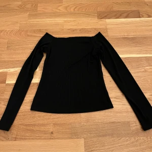 Svart offshoulder topp - Snygg svart offshoulder topp med långa ärmar och ribbad design. 