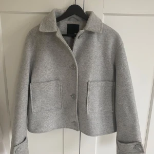 Grå kappa från 157 - Snygg grå kappa från 157 med stora fickor och knappar framtill. Jackan är knappt använd och jag säljer den just för att den inte kommer till användning☺️Mycket bra skick