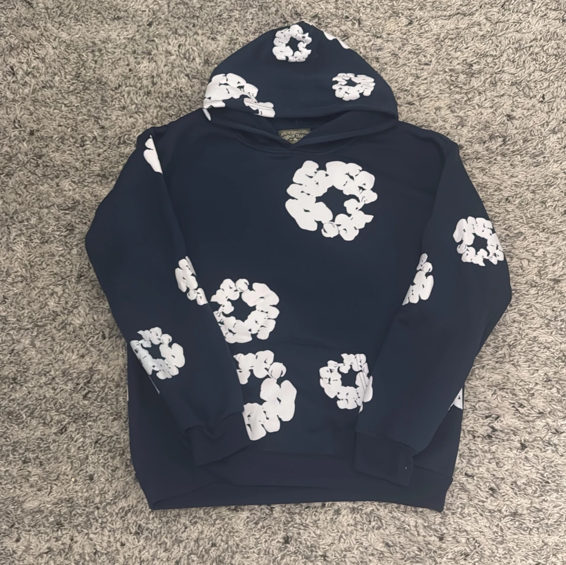 Mörkblå hoodie med blommönster från Denim Tears