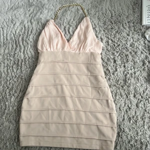 Klänning - Super söt kort klänning med en fin guld detalj. Klänningen är i storlek xs och är öppen i ryggen, den är heller inte genomskinlig. Hör av er vid frågor💞