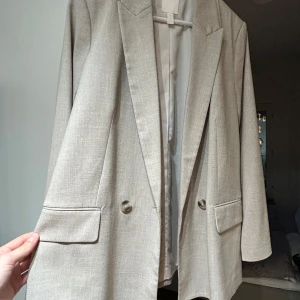 Blazer/kavaj - Beige dubbelknäppt kavaj från H&M. Fint skick. Storlek 40 men passar mig som är S/36, ger då en diskret oversized look. 