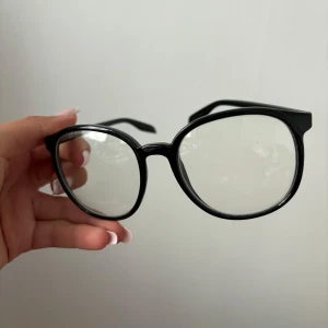Svarta glasögon med rund form - Säljer ett par stilrena svarta glasögon med rund form utan styrka.  De har en klassisk look som passar till alla outfits. Perfekta för både vardag och fest! Aldrig använda. 