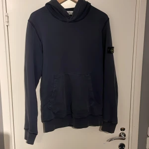 Stone island hoodie - Säljer nu min Stone island hoodie då den inte kommer till användning längre. Den är lite urtvättad så har tappat lite färg men inga fläckar på den, Hoodien sitter större än 14 passar om man har S. Tveka inte på att skriva vid fler frågor Mvh Elias🙌🏼