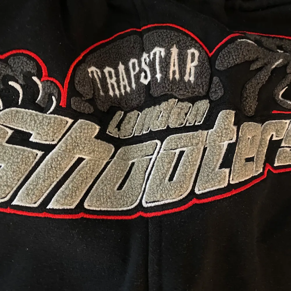 Säljer Trapstar Shooter i svart och röd färg, hoodie och byxor ingår om man köper så får man båda, storlek M och skick är 10/10 användt bara ett par gånger och har inga hål eller fläckor, kan mötas upp i uppsala.. Hoodies.