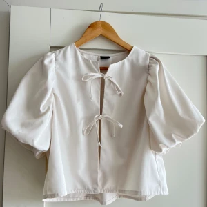 Blus med knytning - Så fin blus som endast är använd en gång! Två knytningar fram och puffärmar, ingen stretch och normal i storlek🌸🩷