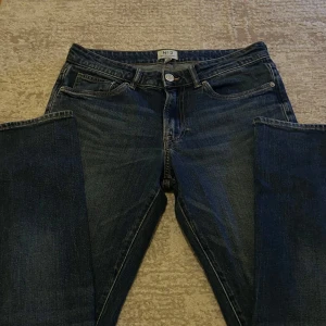 Mörkblå jeans från H&M Essentials - Snygga mörkblå jeans från H&M Essentials med regular fit. Klassisk design med fem fickor och knappgylf. Perfekta för en avslappnad stil.