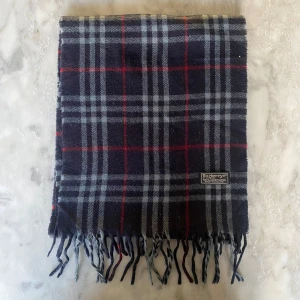 Mörkblå burberry halsduk  - Skick: 8/10. Halsduken är i bra skick och har inga defekter. Mått: 146cm x 29cm
