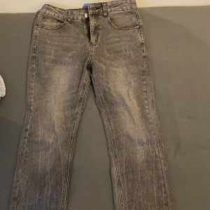 Grå jeansbyxor - Snygga grå jeans med en klassisk design och dragkedja. Perfekta för en avslappnad stil. Midjan är normal och byxorna har en rak passform. Priset kan sänkas 