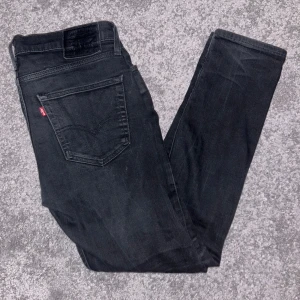 Svarta jeans från Levi's - Snygga svarta jeans från Levi's med en klassisk femficksdesign. De har en dragkedja och knapp framtill. Perfekta för en stilren look.