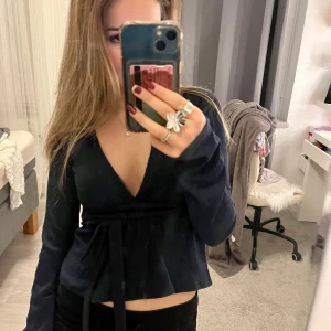 Svart v-ringad topp med knytband - Snygg svart v-ringad topp med långa ärmar och knytband i midjan.❤️