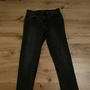 Svarta jeans från Lee - Snygga svarta jeans från Lee med klassisk femficksdesign. De har en dragkedja och knapp framtill. Perfekta för en stilren look.