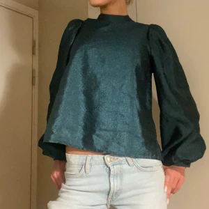 Mörkgrön blus med puffärmar - Snygg mörkgrön blus med långa puffärmar och  knappdetalj i nacken! Köpt på dressingroom, använd en gång