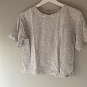 T-shirt i olika färger med NYC-broderi - Säljer tre t-shirts i olika färger: grå, orange och mintgrön. Alla har ett diskret NYC-broderi på bröstet. Perfekt för en avslappnad stil. T-shirtsen är kortärmade och har en normal passform.