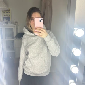 Grå hoodie - Säljer en stilren grå hoodie med en klassisk design. Tröjan har en stor ficka framtill och en bekväm huva. Perfekt för en avslappnad look. Använde lite men nu är den för liten för mig så därför säljer jag nu den.