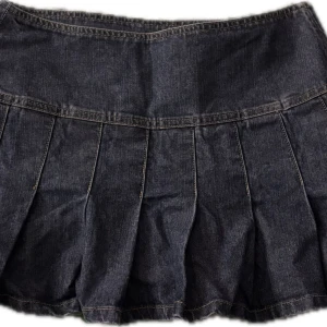 Jeanskjol med dragkedja - Snygg jeanskjol med dragkedja bak. Kjolen har en kort längd och veckad design som ger en cool look. Perfekt för att matcha med olika toppar och accessoarer.