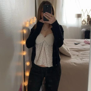 Beige bandeau topp - Säljer en söt beige bandeau topp med broderade detaljer och knyt framtill. Har en feminin och luftig design, perfekt för varmare dagar. Passar bra till både jeans och kjol. Storlek xs men passar även xxs. 