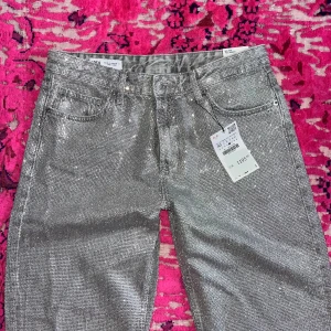 Glittriga jeans från Zara med diamanter  - Nya jeans från Zara med diamanter i 40. Ganska lågmidjade och wide leg. Slutsålda online 