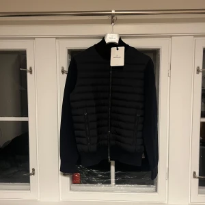 Helt ny Moncler cardigan (oanvänd). - Hej! Jag säljer en helt ny Moncler black label cardigan   Padded cotton zip-up cardigan    Helt ny med tags   Klädhängare och påse följer också med   Autentiskt bevis kommer att skickas vid intresse för köp    Storlek L passar M/L    Köpt ny för 13 600 NOK   Fick den i julklapp och den passade inte, därför säljer jag den    Definitivt den finaste cardiganen på marknaden, så här har du en möjlighet att få ett bra pris med tanke på att den är helt ny    Paketet skickas med posten (norska frakt)