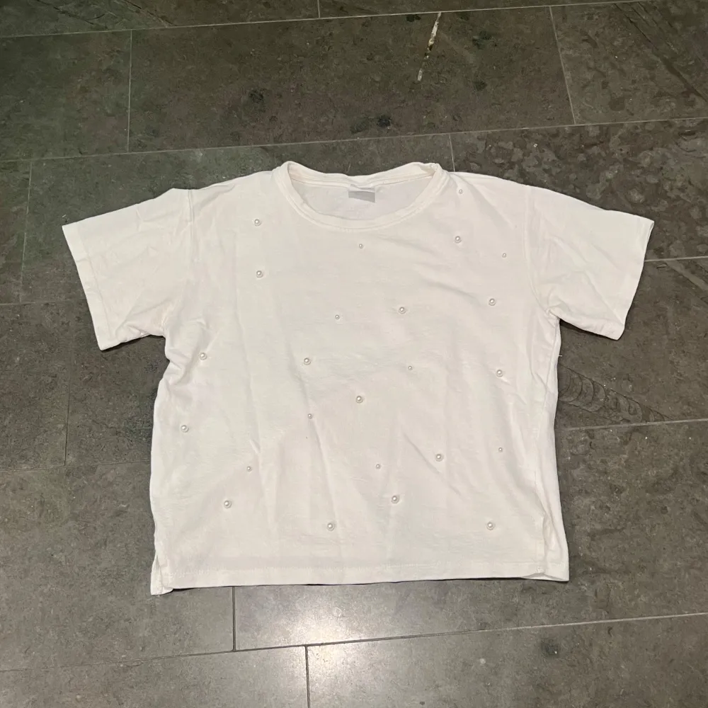 Säljer en söt vit T-shirt med pärlor på framsidan från Zara ☀️❗️Skriv om du vill ha fler bilder❗️ Storlek: 13-14år, 164 Nyrpis: Ca 250kr. T-paidat.