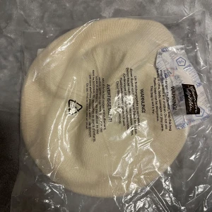 Basker i lammull - Snygg basker i lammull, i krämvit. Perfekt för att hålla värmen med stil. One size passar de flesta. Säljer för ligger bara och tar plats helt nya och oanvända samt ej upp tagna ur förpackning.   Priset kan sänkas vid snabb affär. 