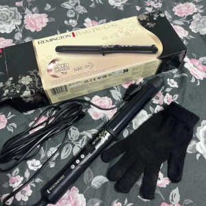 Remington Pearl Pro Curl Locktång - Säljer en Remington Pearl Pro Curl locktång. Den har en elegant svart design med pärldetaljer och kommer med en värmeskyddande handske och en förvaringspåse. Perfekt för att skapa vackra lockar med en max temperatur på 210°C.