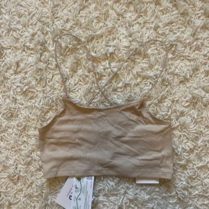 Topp - Beige topp ifrån NA-KD storleken XSS, men skulle säga att den passar även XS. Aldrig använd och med prislappar kvar. Pris går att diskutera och jag kan skicka fler bilder💕