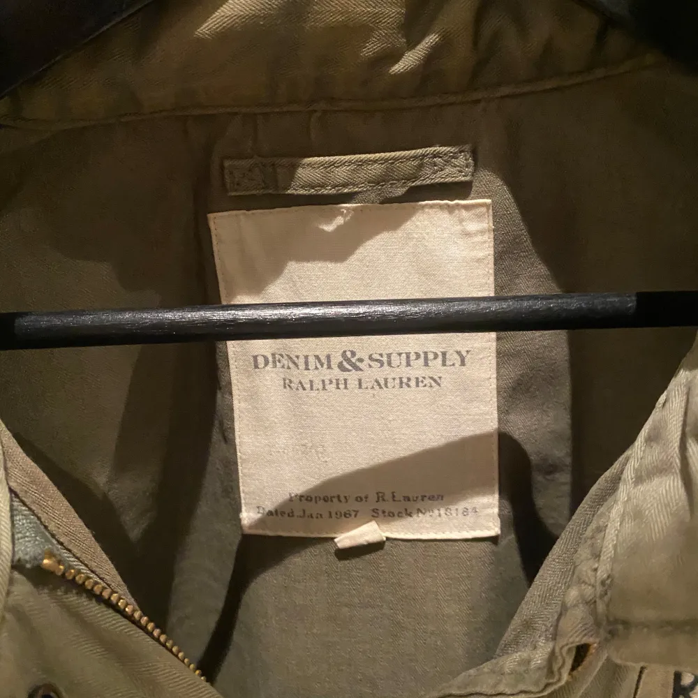 Säljer en grön jacka från Ralph Lauren's Denim & Supply. Jackan har flera fickor och en dragkedja framtill. Den har en cool militärinspirerad look med broderade detaljer på bröstet. Perfekt för en avslappnad stil.. Takit.