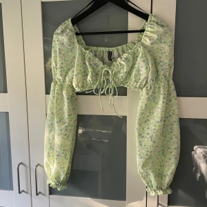 Topp - Kort topp med långa ärmar i lite ballongmodell. Knytning fram så storlek runt om kan anpassas. Enligt plagg storlek XS men skulle säga att det passar XS-S/liten M beroende byststorlek! 