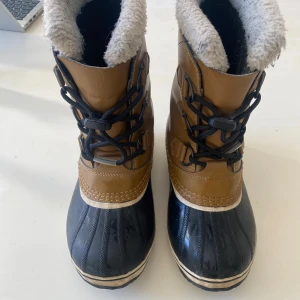 Vinterskor från Sorel - stl 35 (nypris ca 1200 kr) - Vinterskor från Sorel  • Vattentäta, varmfodrade kängor • Helgjuten fot i gummi • Skaft i läder med en PU-beläggning • Snörning • Tejpade sömmar • Krage i teddy • Mellansula med kylbarriär • Varmfodrad med uttagbar och tvättbar filtad innersocka