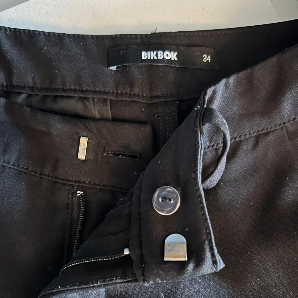 Säljer ett par svarta byxor från BikBok i storlek 34. De är högmidjade och har en slim passform med dragkedja och knapp framtill. Perfekta för både vardag och fest!. Jeans & Byxor.