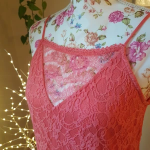 Mjuk, stretchig spetsklänning - Anv en gång. Korallfärg (svår att få rättvis bild på), passar XS/S. Lite asymmetrisk fåll nedtill. ~ STOR rensning & klänningsbonanza i min shop ~ Välj 5 för 100kr oavsett pris, skicka medd/lämna som prisförslag (gäller där det står) ~