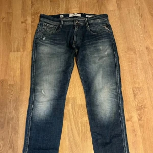 Replay jeans med slitningar  - Riktigt feta replay jeans i storlek 32/32. Aged 05 annbass där av slitningarna (från fabrik). Säljer  de för det ej passade. Fint skick. Hör av er vid frågor eller funderingar!