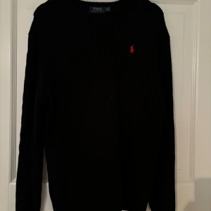 Kabelstickad Polo Raplh Lauren tröja - Säljer denna feta kabelstickade Ralph tröjan för att den inte har kommit till så mycket användning. Den är i mycket bra skick eftersom att den knappt har använts. Ny pris är runt 2000kr