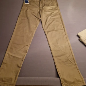 Oanvända Jack & Jones Chinos - Oanvända med allt kvar så de e som nya. De är ett par chinos från Jack & Jones i färgen Beige/Khaki i storlek W32 L36