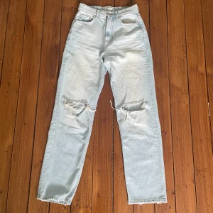 90 high waist jeans  - 90 high waist jeans ifrån Gina Tricot. Ljusblåa med slitningar på knäna. Endast använda 1 gång så i väldigt fint skick. Storlek 34, skulle säga att de är normala i storleken