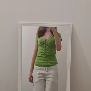 Tshirt med knäppning - Söt typ ärtgrön tshirt som man kan knäppa upp eller ner hur man vill. Lappen där det stod märket är borta tyvärr annars fint skick