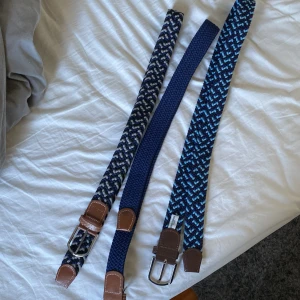 Flera flätade bälten i olika mönster - Säljer tre snygga flätade bälten i olika blå nyanser. Ett har ett coolt mönster i blått och svart, ett annat är helblått och det tredje har ett mönster i ljusblått och svart. Alla bälten har bruna läderdetaljer och silverfärgade spännen. Perfekta för att ge din outfit en stilren touch! Alla 3 för 499!