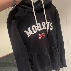 Morris hoodie  - Säljer denna riktigt populära Morris hoodie i bra skick. Den är sparsamt använd. Den är mörkblå och har de populära märket på framsidan. Hoodie har även metal detaljer på snörena där det står morrris på. Vid fler frågor är det bara att höra av sig. 