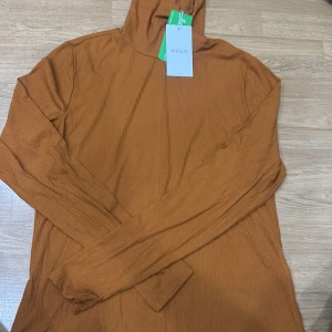 Orange ribbad hoodie från Vila - Säljer en snygg orange ribbad hoodie från Vila i storlek M. Perfekt för höst och vår med sin varma färg och bekväma passform. Den har långa ärmar och en klassisk huva. Perfekt för en casual look eller mysiga dagar hemma. 🧡