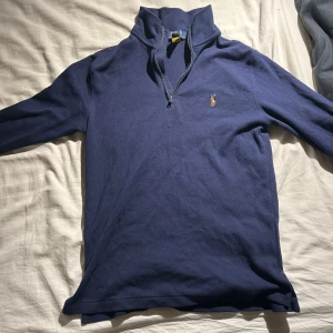 Mörkblå tröja från Polo Ralph Lauren - Säljer en snygg mörkblå tröja från Polo Ralph Lauren. Den har en dragkedja vid halsen och det klassiska logotypbroderiet på bröstet. Perfekt för både vardag och lite finare tillfällen. Tröjan är i bra skick och passar perfekt till höst och vår. Nypris 1000.