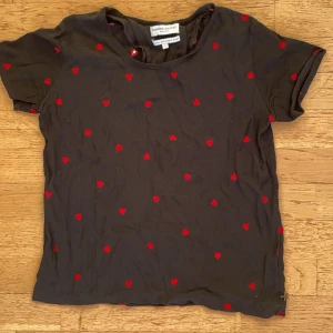 Svart t-shirt med röda hjärtan - Säljer en svart t-shirt med röda hjärtan över hela tyget. Den är i bra skick ❤️